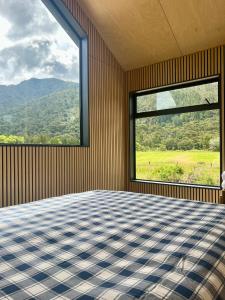 a room with a bed and a large window at Hikuai Hideaway in Hikuai