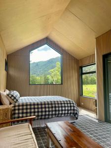 a bedroom with two beds and a large window at Hikuai Hideaway in Hikuai