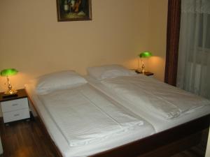 a bed with white sheets and pillows on it at Pension Schottentor in Vienna