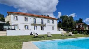 a house with a swimming pool in front of a house at Casal Magister in Pedraça