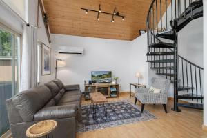 a living room with a couch and a spiral staircase at Raven Haven Lodge by NW Comfy Cabins in Leavenworth