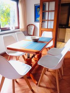 a dining room with a table and white chairs at Landhaus Eva-Maria in Elbingerode