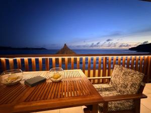a wooden table on a balcony with a view of the ocean at Beach front luxury living - 2 bedroom condo with sea view in Jan Thiel