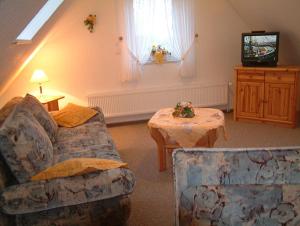 Una sala de estar con un sofá, una mesa y un televisor. en Haus Nordstrand Vereinsalle 21WHG 2 6, en Büsum