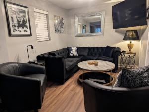 a living room with a black couch and a table at The Hillside Hottie! in Corydon