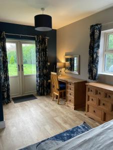 a bedroom with a desk and a mirror at Greenway Cottage in Baltonʼs Cross Roads