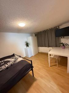 a bedroom with a bed and a table and a desk at Nest-Unterkunft in Bad Überkingen