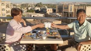 a man and a woman sitting at a table with food at Siwa Star Rooms in Siwa
