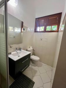 a bathroom with a sink and a toilet at Le Coin Tranquille in Sainte-Anne +24 photos