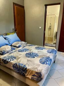 a bed with blue and white sheets in a room at Le Coin Tranquille in Sainte-Anne