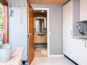 a bathroom with a sink and a door leading into a room at 4 person holiday home in Juelsminde in Snaptun