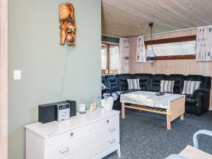 a living room with a couch and a table at 4 person holiday home in Juelsminde in Snaptun