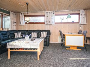 a living room with a couch and a table at 4 person holiday home in Juelsminde in Snaptun