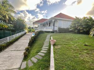 a house with a flower pot in the yard at Le Coin Tranquille in Sainte-Anne