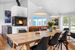 a dining room with a table and a fireplace at 931-Thisted-Pinbak-24 in Torsted