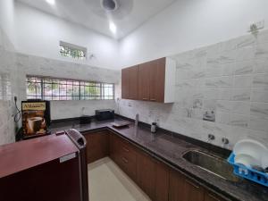 a kitchen with a sink and a counter top at Green Villa - Luxury Rooms at peaceful location -200 mtrs away from Bus Stand -500 mtrs from Udaipur Railway Station - Family Suites w Kitchen also available in Udaipur
