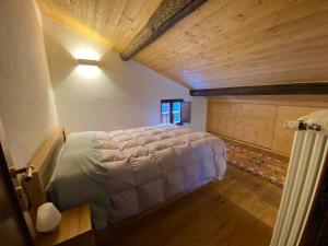 a large bed in a room with a wooden ceiling at Villa Vetto in Lanzada