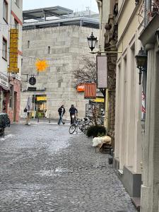 a cobblestone street in a city with people walking around at Haus Zum Bacchus Privates Unterkunft nahe Bahnhof Römisches Theater, Mainz in Mainz