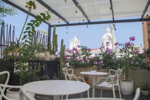 a patio with tables and chairs and potted plants at Casa Verde Boutique Hotel in Santa Marta