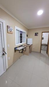 an empty kitchen with a desk and a refrigerator at Cantinho do sossego in Capão da Canoa
