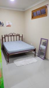 a bed sitting in a room with a mirror at Cantinho do sossego in Capão da Canoa