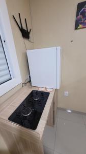 a kitchen with a stove and a white refrigerator at Cantinho do sossego in Capão da Canoa +4 photos