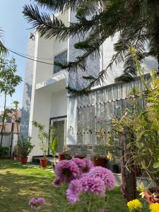 a white building with purple flowers in front of it at Green Villa - Luxury Rooms at peaceful location -200 mtrs away from Bus Stand -500 mtrs from Udaipur Railway Station - Family Suites w Kitchen also available in Udaipur