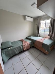 a bedroom with two beds and a window at Apartamento confortável in São Luís
