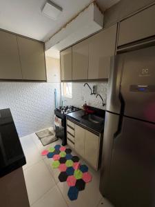 a kitchen with a refrigerator and a rug on the floor at Apartamento confortável in São Luís