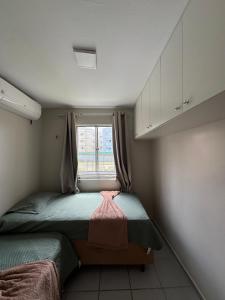 a small bedroom with two beds and a window at Apartamento confortável in São Luís +1 photo