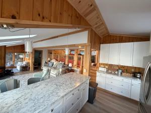 a kitchen with a counter top and a living room at Barnacle - quiet family Maine waterfront getaway in Orrs Island