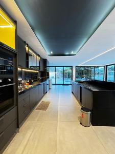 a large kitchen with black cabinets and a large window at Resilience Igaratá in Igaratá