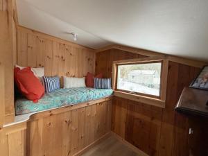a bench in a wooden room with a window at Barnacle - quiet family Maine waterfront getaway in Orrs Island