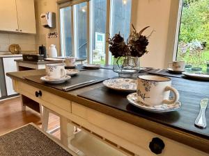a kitchen with a table with cups and plates on it at Barso Home Puerto Natales in Puerto Natales