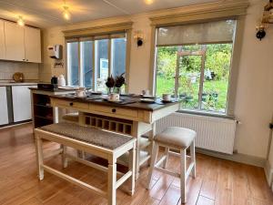 a kitchen with a table and two stools in it at Barso Home Puerto Natales in Puerto Natales