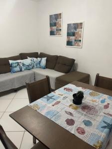 a living room with a table and a couch at Apt 2 quartos- Leia sobre a propriedade in Itamaracá
