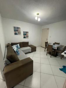 a living room with a couch and a table at Apt 2 quartos- Leia sobre a propriedade in Itamaracá