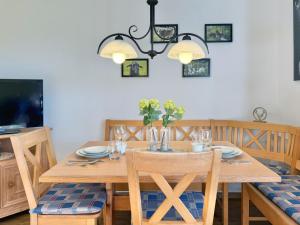 a dining room with a wooden table with flowers on it at Sonnenhof Seeg 04 in Seeg