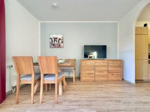 a dining room with a table and chairs and a television at Sonnenhof Seeg 05 in Seeg
