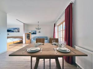 a dining room with a table and a bedroom at Sonnenhof Seeg 05 in Seeg