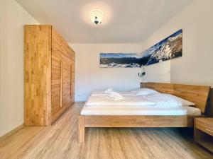 a bedroom with a bed and a wooden cabinet at Sonnenhof Seeg 05 in Seeg +13 photos