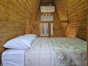 a bedroom with a bed in a wooden cabin at Chalé solmar in Penha