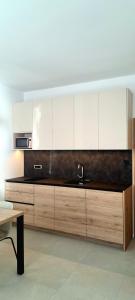 a kitchen with white cabinets and a sink at River2Mountain Cozy Apartment in Gozd Martuljek