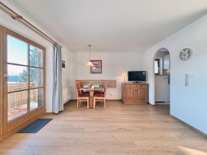 a living room with a dining room table and a window at Sonnenhof Seeg 07 in Seeg