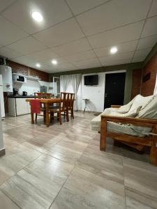 a room with a table and chairs and a kitchen at Departamento Boulevard in Malargüe
