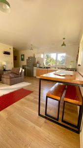 a kitchen and living room with a table and a couch at Cabaña con jacuzzi exterior y vista al mar - Huellas de Pato, Puerto Montt in Puerto Montt