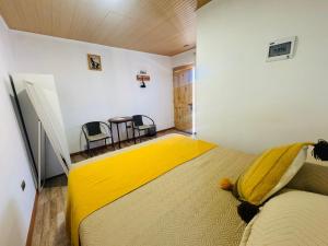 a bedroom with a bed with a yellow blanket on it at Casa Ñawi in San Pedro de Atacama