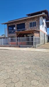 a building with a fence in front of it at Pousada Ju Haus in Navegantes