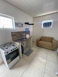 a kitchen with a stove and a sink and a couch at ML Integra Mix kitnets in Maceió