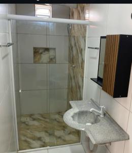 a bathroom with a sink and a glass shower at ML Integra Mix kitnets in Maceió
